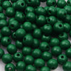 A pile of natural wooden beads in various shades of green for jewelry making and DIY crafts.