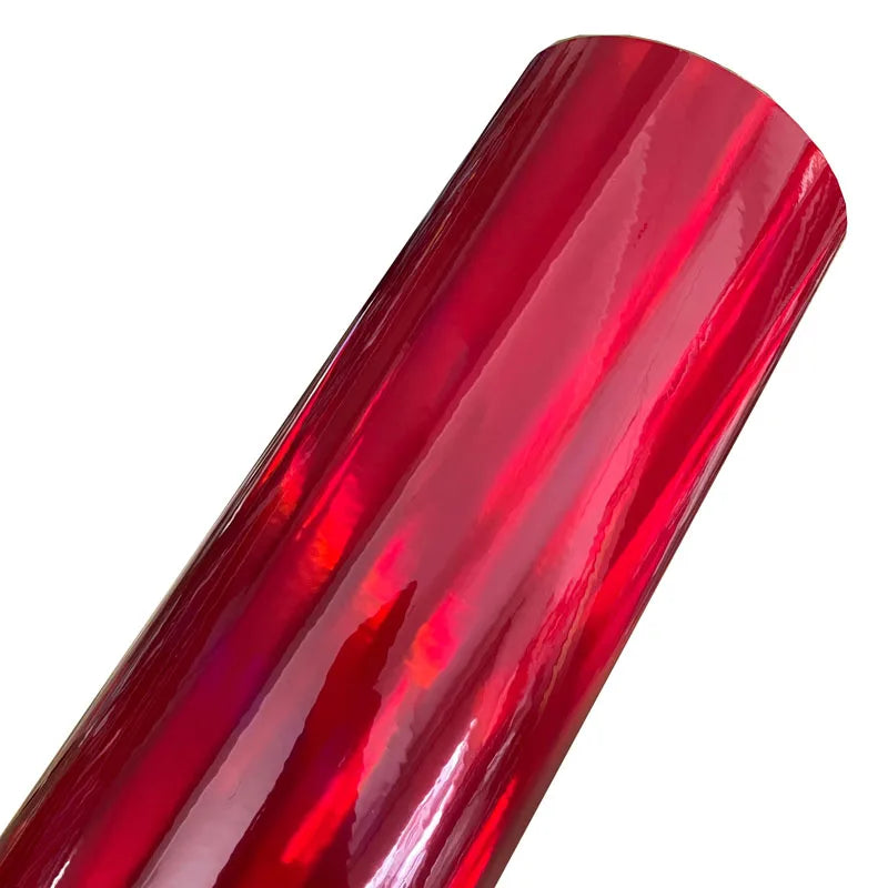 A close-up view of a roll of holographic chrome vinyl wrap in a vibrant red finish.