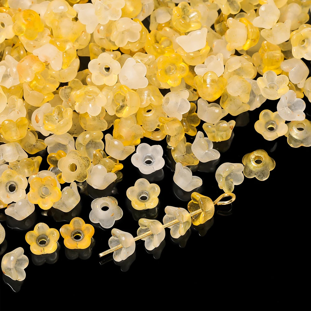 A pile of gradient yellow and white bellflower acrylic beads for jewelry making