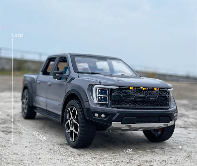 A gray 1:20 scale Ford Raptor F150 diecast model truck with lights and sound effects parked on a concrete surface.
