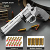 A silver pistol is shown next to soft bullet and bullet shells for a dart blaster product.