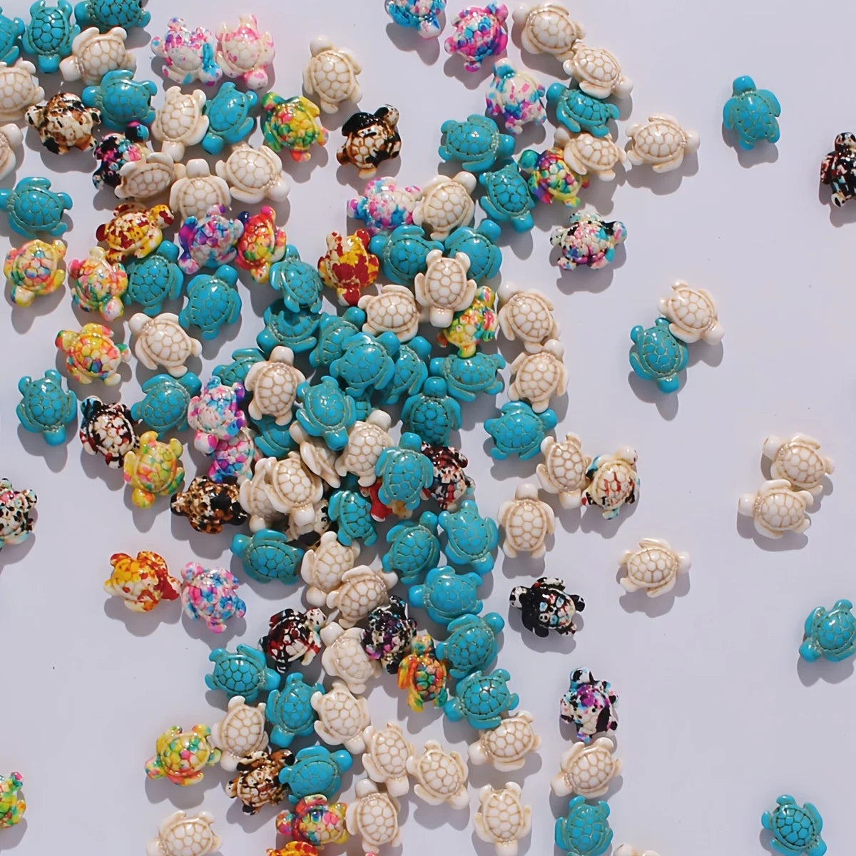A collection of multicolor ocean turtle beads in various shades of blue, white, and pink for jewelry making.