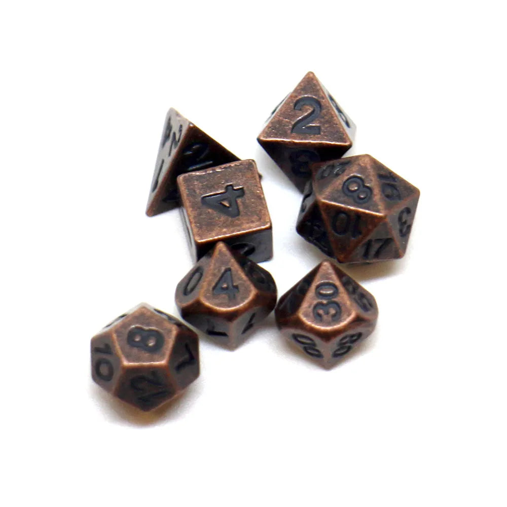 A set of seven antique metal polyhedral dice, including a d4, d6, d8, d10, d12, d20, and d30.