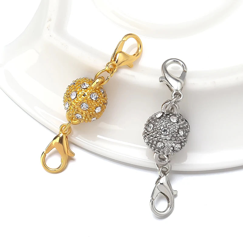 Gold and silver magnetic clasps for jewelry making displayed on a white surface.