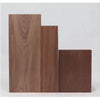 Three vertical rectangular boards of dark brown walnut wood stacked side by side