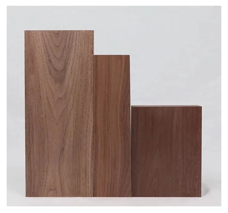 Three vertical rectangular boards of dark brown walnut wood stacked side by side