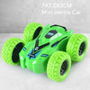 A bright green mini inertia car toy with large rubber wheels is shown on a white surface.
