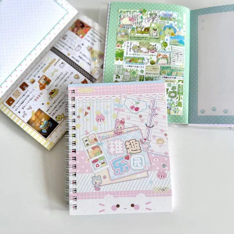 A pink and white spiral notebook filled with cute stickers and illustrations, next to an open green book.