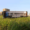 A 1:50 scale diecast alloy container truck with lights and sounds displayed on grass.