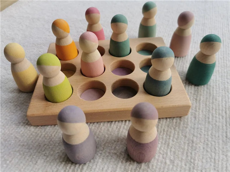 A wooden stacking block set featuring pastel colored, stylized human figures arranged in a grid on a light surface.