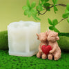 A set of four silicone candle molds shaped like Highland cows resting on green moss.