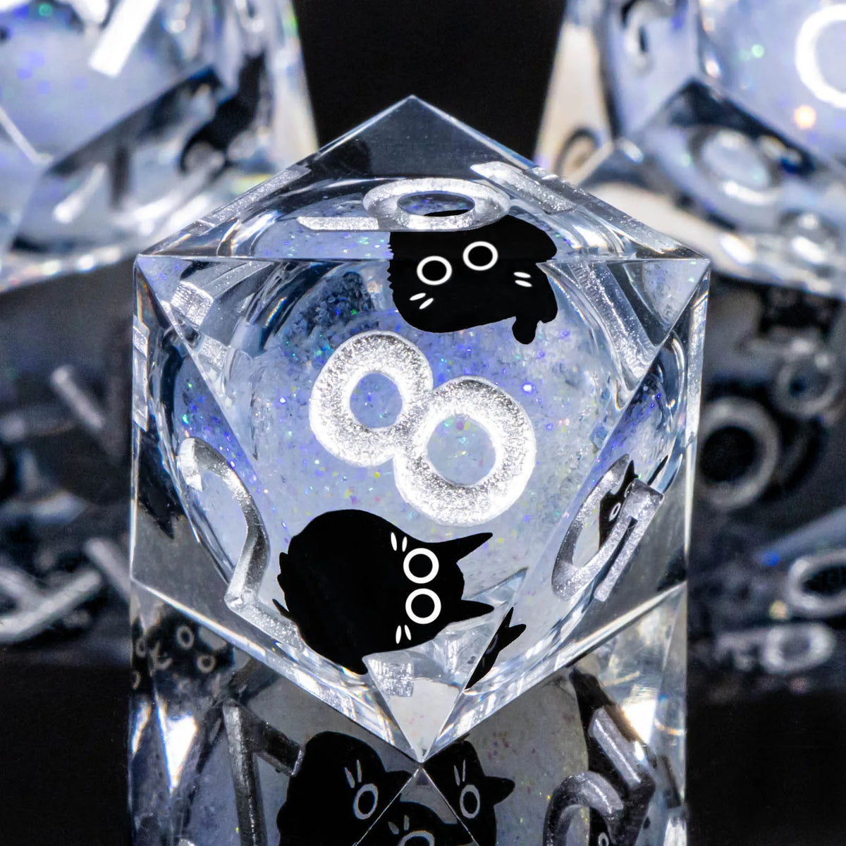 A clear resin die with a diamond cut featuring a black cat silhouette and an infinity symbol.