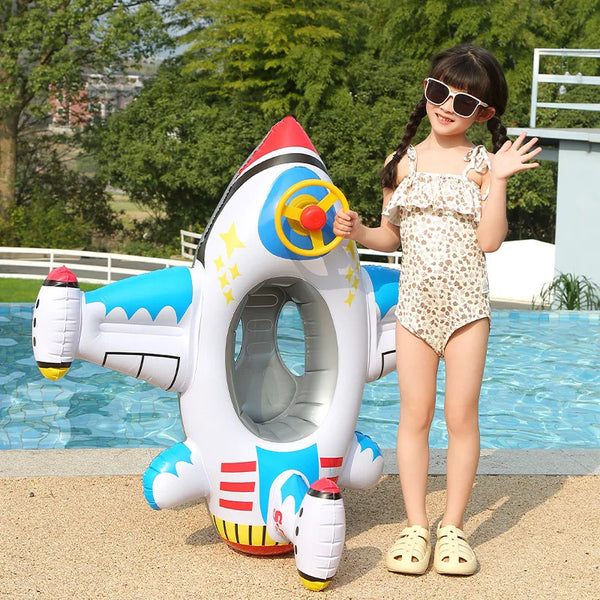 A young girl is posing with a white inflatable aircraft swim ring for kids in a swimming pool.