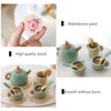 A set of wooden pretend play kitchen items including a teapot, cups, and accessories with watercolor paint finish.