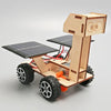 A wooden model kit of a solar-powered lunar rover featuring large wheels and solar panels.