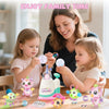 A mother and two young children are shown enjoying a DIY balloon animal craft kit with pump, stickers, and decorations.