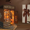 A wooden miniature kit of a magic wand shop display featuring an illuminated storefront and wooden elements.