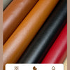 A close-up of various colors of self-adhesive leather patches, including brown, orange, black, and red.