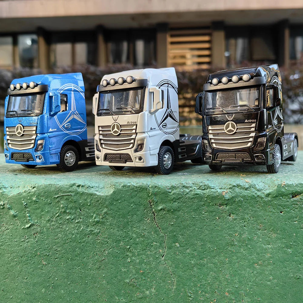Three diecast model trucks of different colors, including blue, white, and black, parked on a green surface.