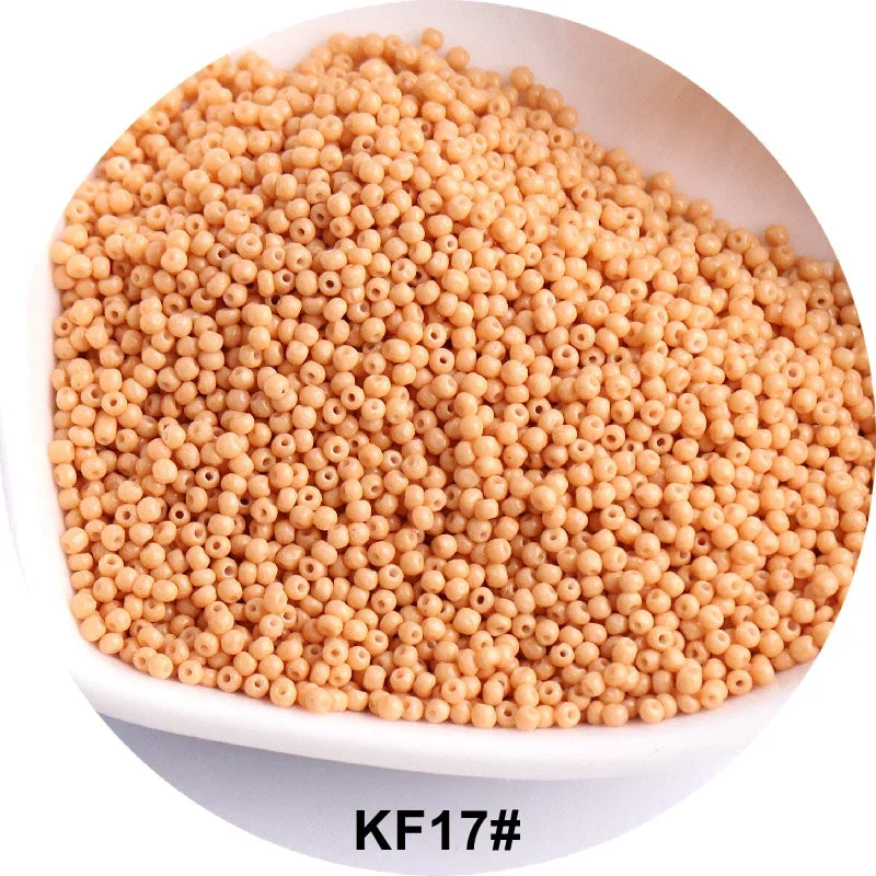 A pile of light beige spherical glass seed beads for jewelry and craft.