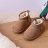A pair of brown suede winter snow boots with faux fur lining resting on a wooden surface.