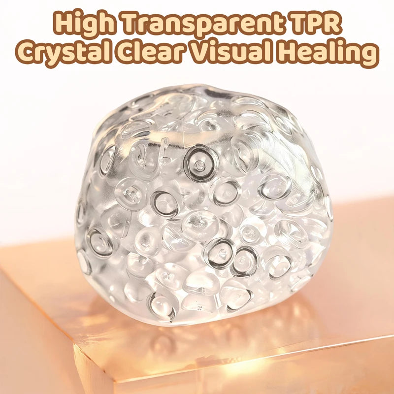 A clear, spherical TPR crystal healing ball resting on a wooden surface.