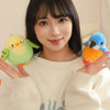 A young woman holds a yellow cartoon bird plush toy in front of her face.