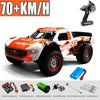 An orange and white high-speed 4WD brushless RC monster truck with a remote control visible.
