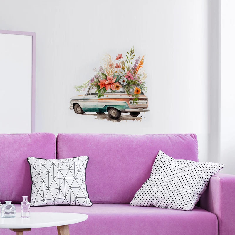 A vintage light green truck decorated with colorful floral stickers mounted on a white wall.