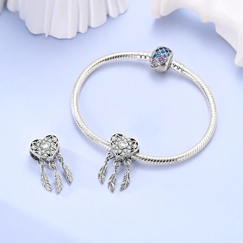 Sterling silver heart charm beads for bracelets featuring a blue gemstone and dangling charms