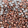A close-up view of various flatback rhinestones in silver and rose gold tones for nail art and crafts.