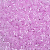 A close-up view of a colorful mix of pink and purple glass beads for jewelry making.