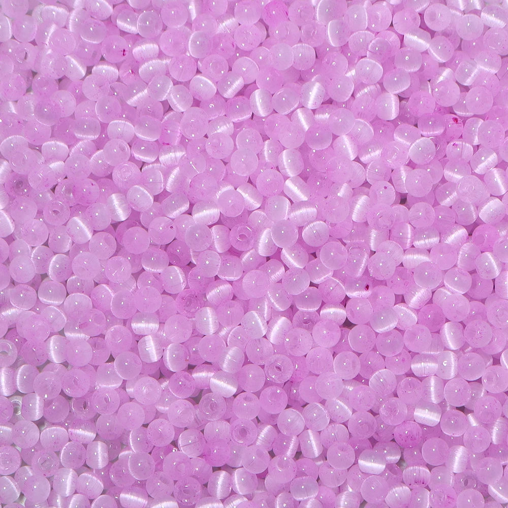 A close-up view of a colorful mix of pink and purple glass beads for jewelry making.
