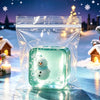 A glowing teal fidget cube shaped like a snowman is visible inside a clear plastic pouch against a snowy, festive background.