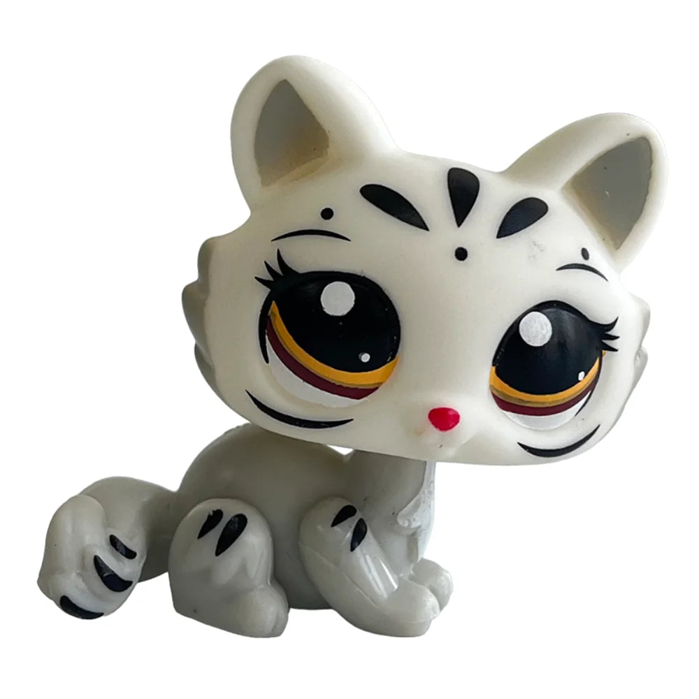 A white ceramic bobblehead figurine of a kitten with large eyes and black markings.