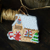 A white diamond painting charm pendant featuring colorful rhinestones and a house design, attached to a gold-colored keychain