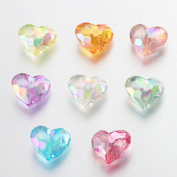 A collection of twenty heart-shaped acrylic spacer beads in various shades of pink, yellow, and green.