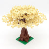 A model of a cherry blossom tree built from yellow LEGO-style bricks with a brown trunk and green base.