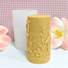 A cylindrical silicone candle mold in a pale yellow color featuring a detailed gothic death angel design.