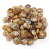 A pile of colorful, translucent amber and brown acrylic beads for jewelry making