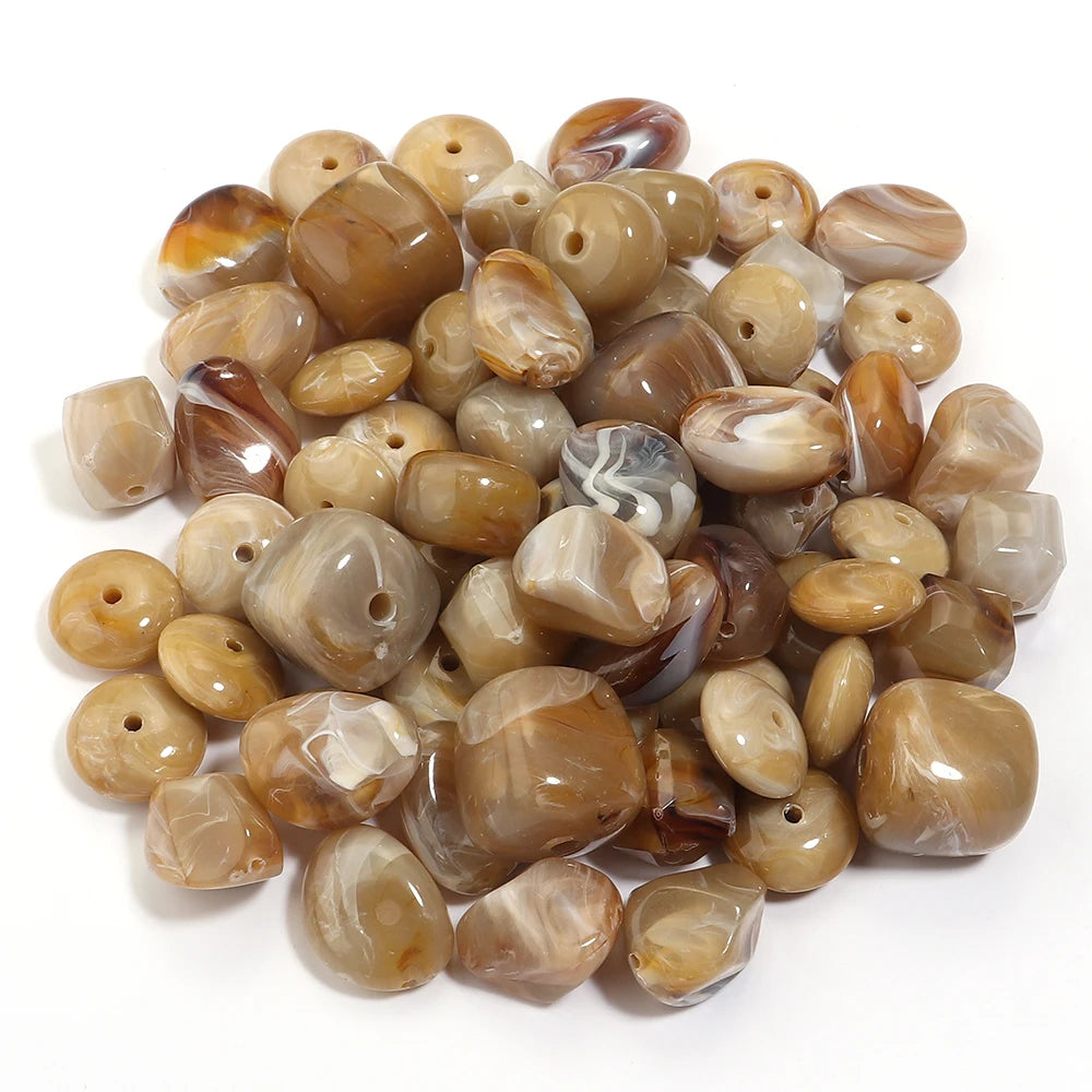 A pile of colorful, translucent amber and brown acrylic beads for jewelry making