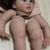 A lifelike reborn baby doll kit featuring painted vinyl parts, shown from the front.