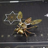 A detailed brass metal bee and wasp puzzle for home decor, set against a dark background.
