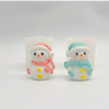 Two silicone molds of smiling snowmen, one pink and one blue, used for crafting candles and resin.