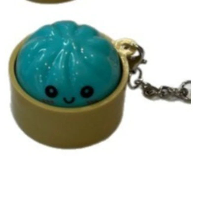 A light blue dumpling-shaped squishy keychain with a gold-colored loop and chain.