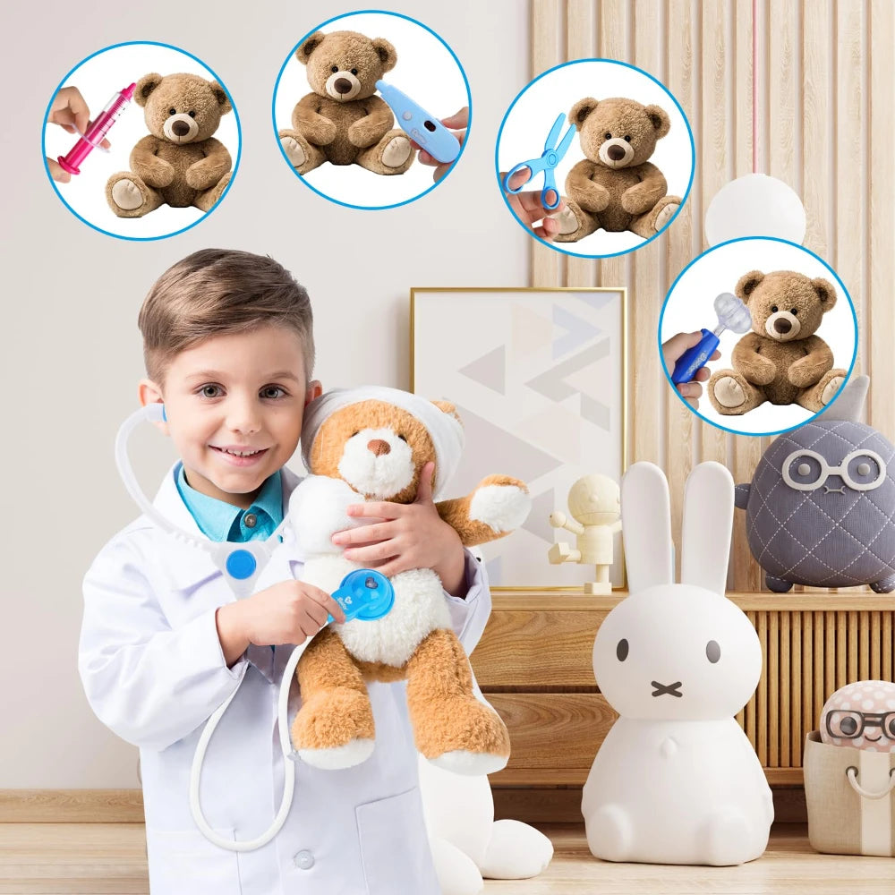 A young boy wearing a doctor's coat is holding a teddy bear and various medical tools like scissors and a stethoscope.