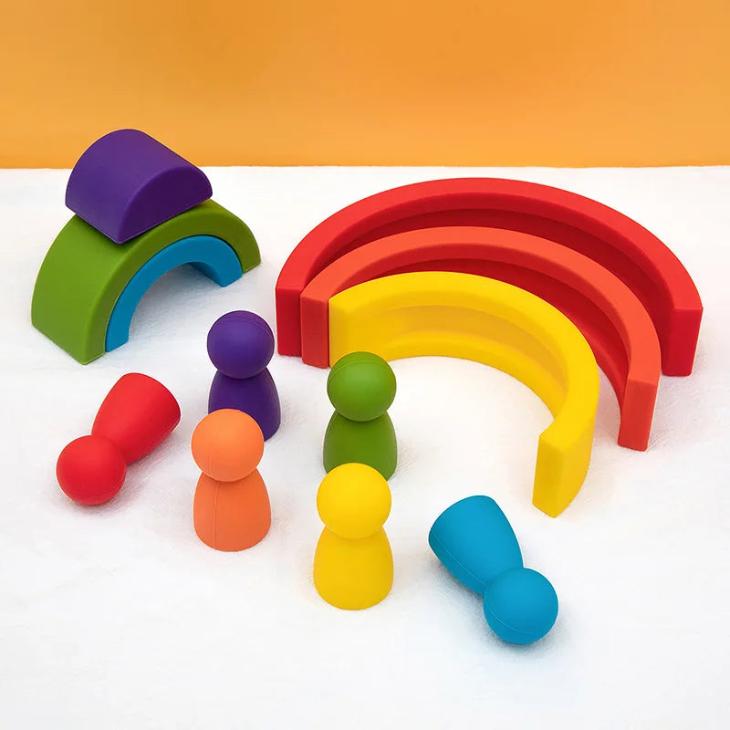 A collection of soft silicone rainbow building blocks in various colors like purple, green, red, yellow, and orange arranged 