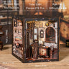 A wooden book nook kit featuring detailed miniature scenes and LED lighting, displayed on a wooden surface.