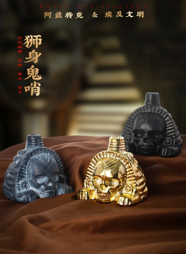 A handcrafted Aztec death whistle featuring a skull design, displayed on brown fabric.