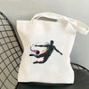 White tote bag featuring a graphic design of a soccer player mid-air with a splash of colored lines.